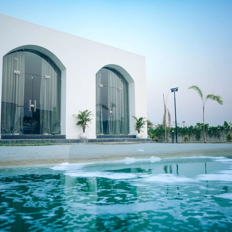 Villa moderna con ventanales en arco frente a la piscina