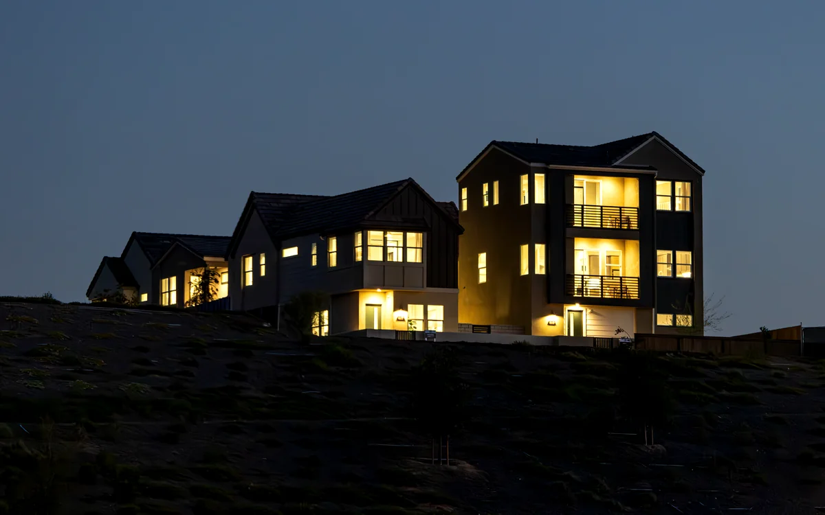 Casa moderna iluminada sobre una colina al anochecer